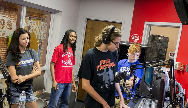-Alton High School student Logan Phillips prepares to go on-air as his fellow classmates, from left, Nicole Matis and J.T. Ammonette, and WLCA Music Director Randy Kinnikin, right, look on. Photo by Louise Jett