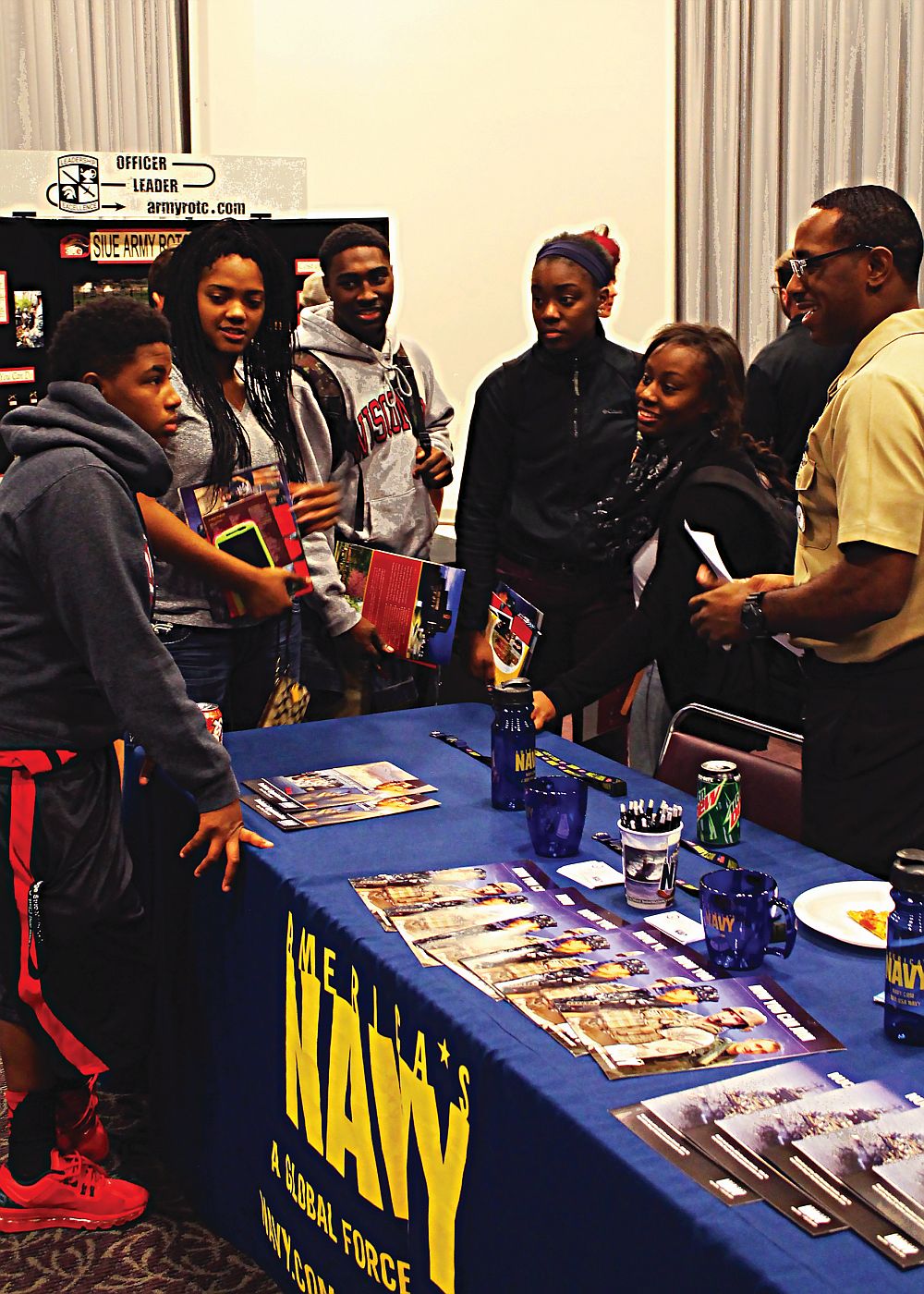 Lewis and Clark students (from left to right): Jekiyah Woods, a dentistry major from Florissant Missouri; Anita Holmes, a special education major from Alton, Illinois; Eldin Salmond, a business major from Madison, Illinois; Makayla Stokes, a psychology major, from Waterloo Iowa; and Shania Robinson also from Waterloo, IA; listening to Operations Specialist, Harvest Hines give information about joining The U.S. Navy at the 2014 Transfer Day.