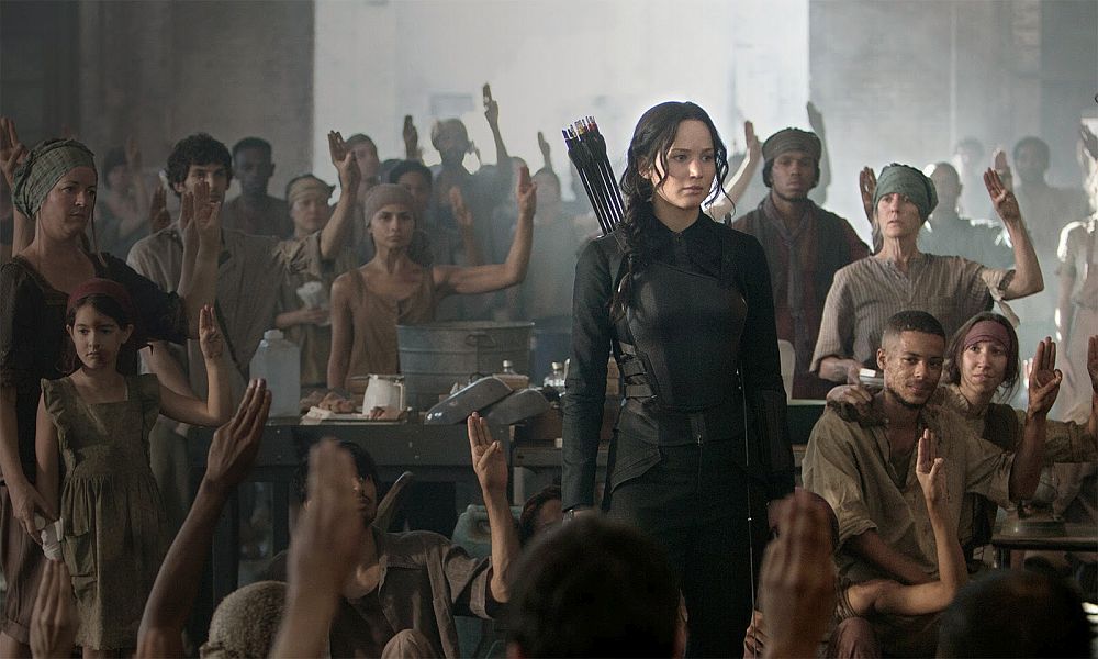 Photo from blackfilm.com   Katniss Everdeen at the makeshift hospital within the battlefield. Everdeen is saluted by her fellow anti-Capitol rebels.  