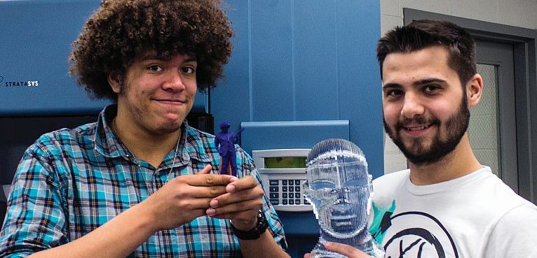 Photo by Julia Johnson Architecture student, Alex Peterson from Edwardsville holds a 3D printed action figure modeled after his own likeness, and drafting student Caleb Martin from Wilsonville, Illinois holds a 3D sculpted model of a head that was carved down from a single piece of plastic.