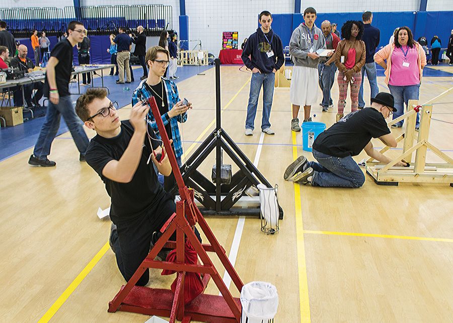 Photo by Julia Johnson Team Klopimia members from Highland High School (F to R): Josh Wagner, Gavin Hemphill and Joshua Kineke working their trebuchets while captain Adam Kelso and Judges watch.