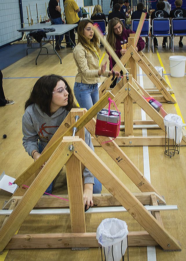 Photo by Julia Johnson All Female Team Fab 5 from East Alton Wood River High School members (front to rear) Riley Wallendorff, Haley Kerpan and Emilee Olinghouse operate their trebuchets in competition.