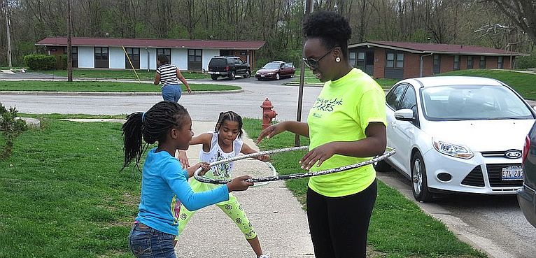 Photo by Jared Hennings for Lewis and Clark Community College. Lewis and Clark Community College students volunteered their services in a variety of locations in our communities as part of L&C Cares April 13-17. The event is being held in conjunction with National Volunteer Week. Pictured are L&C student volunteer Samira Bell playing hula hoop with children at Alton Acres of Alton Housing Authority.