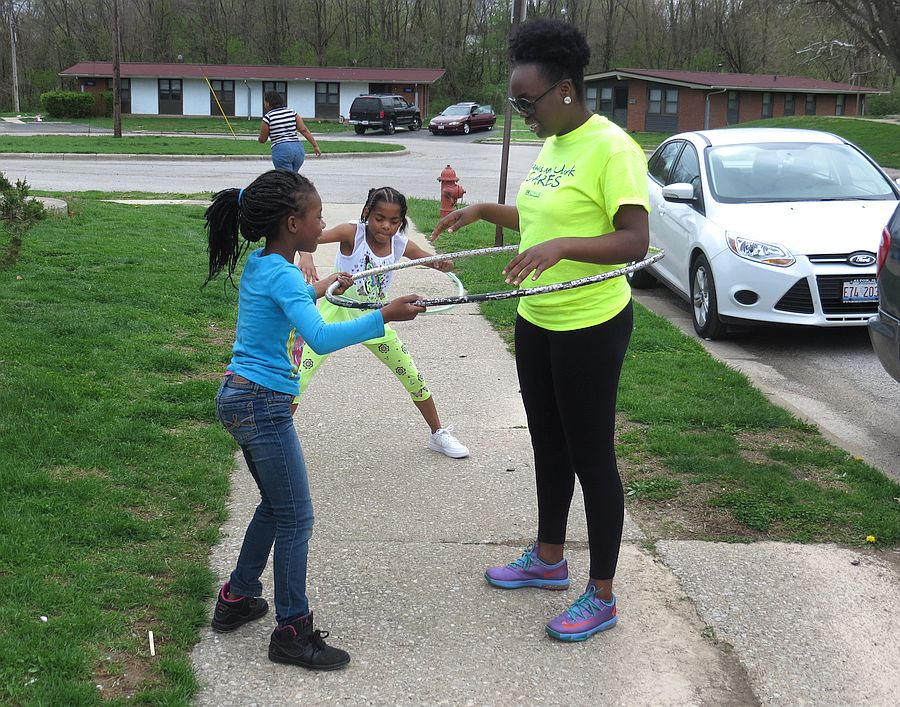 Photo by Jared Hennings for Lewis and Clark Community College. Lewis and Clark Community College students volunteered their services in a variety of locations in our communities as part of L&C Cares April 13-17. The event is being held in conjunction with National Volunteer Week. Pictured are L&C student volunteer Samira Bell playing hula hoop with children at Alton Acres of Alton Housing Authority.