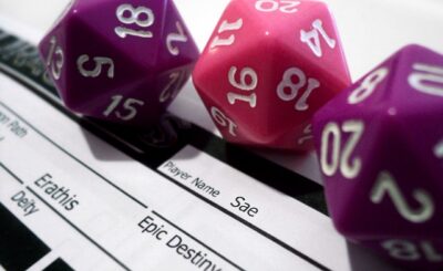 3 20 sided dice sit on a character sheet for dungeons and dragons