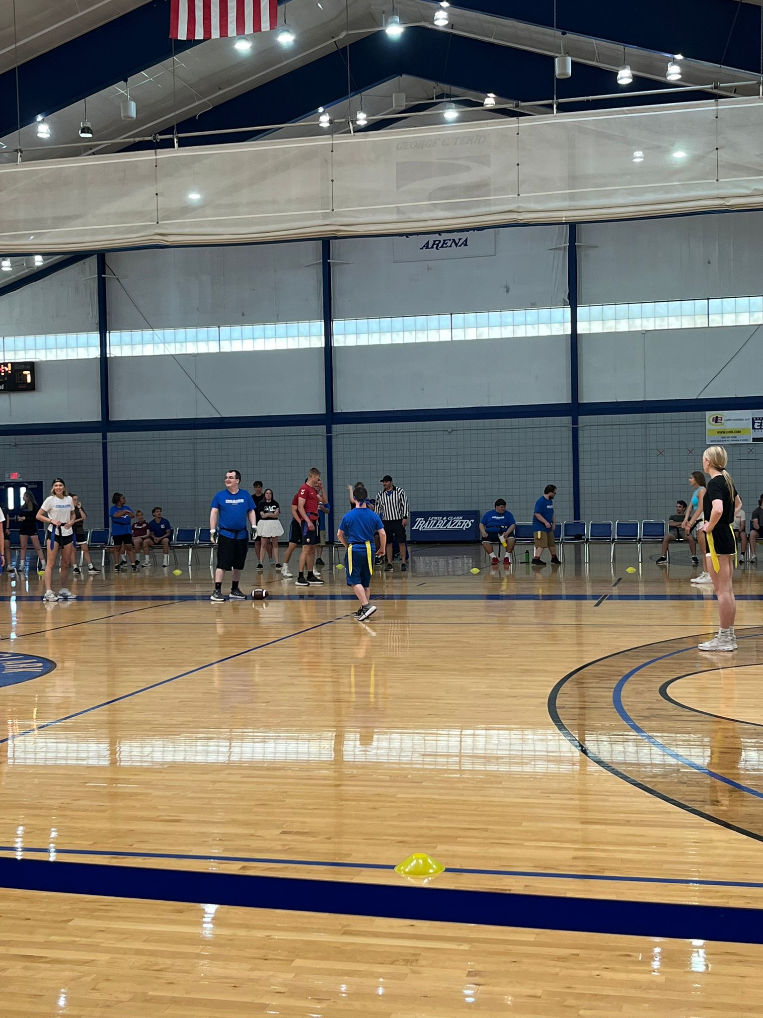 Students participate in a flag football game on an indoor basketball court at the Lewis & Clark Community College arena.
