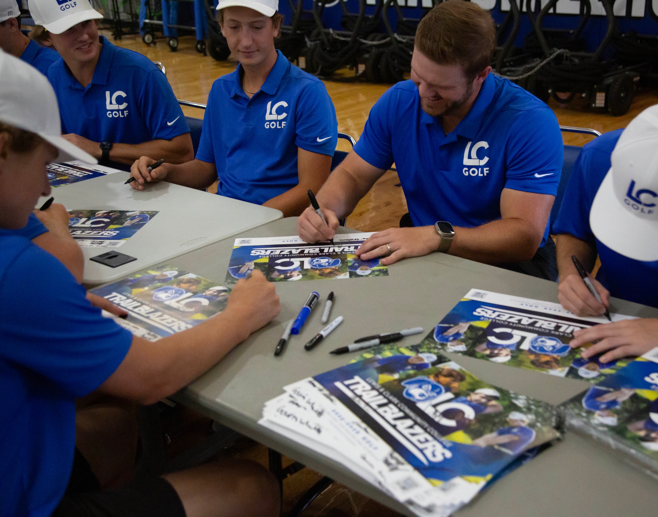LC Golf athletes sign autographs for fans at a table during Media Day.
